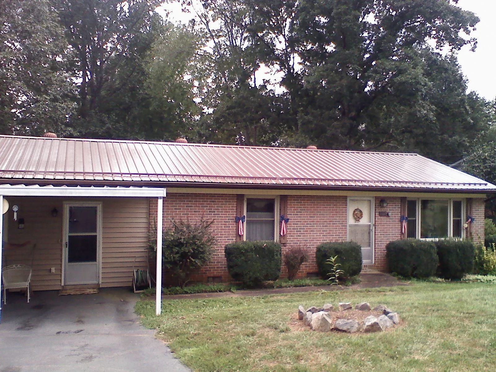 Bronze metal roof and carport on a brick ranch home — Roof Repair work by our crew in Port Murray