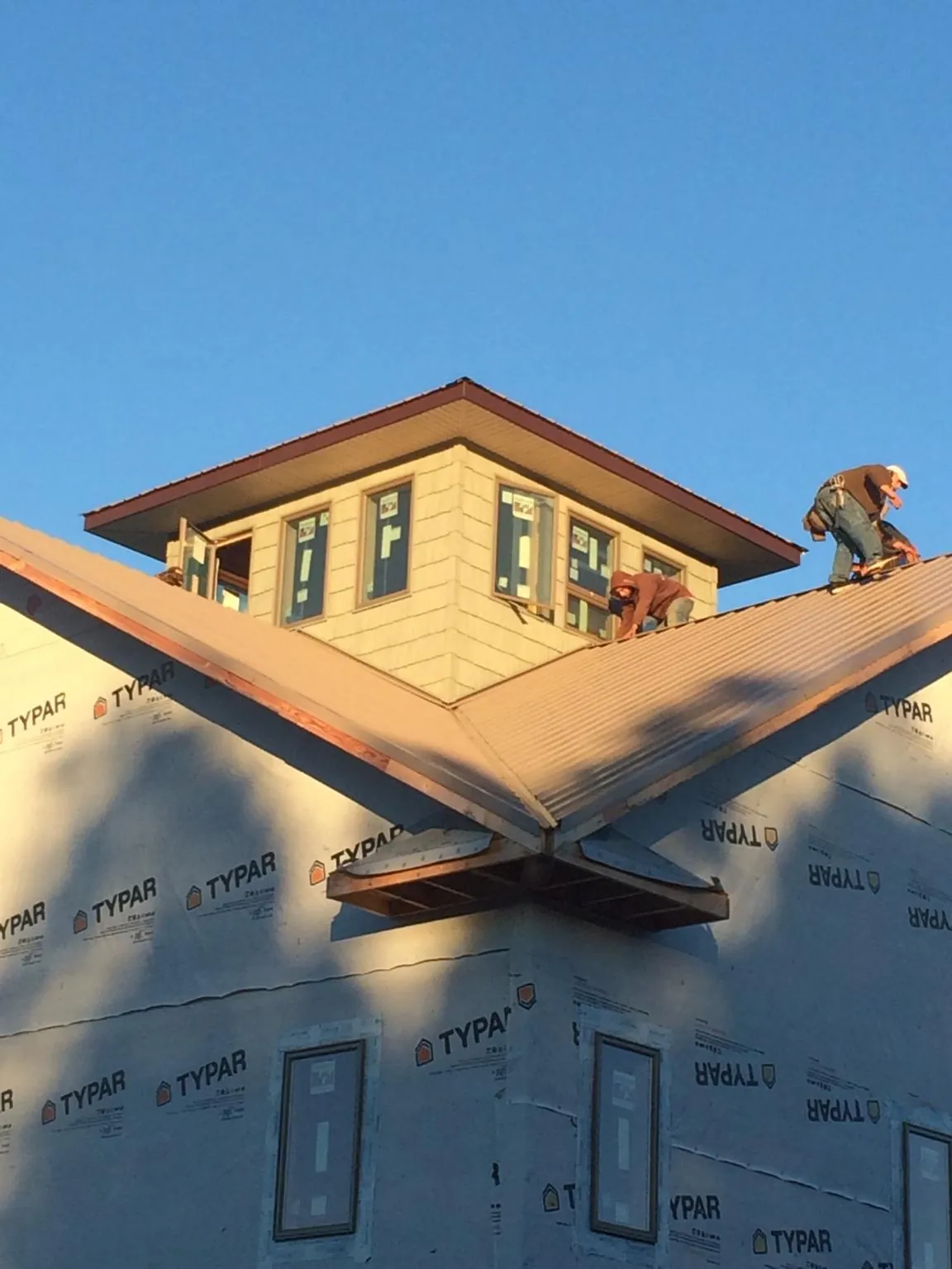 Roofers working around a rooftop cupola on a new metal roof at sunset — Roof Waterproofing in Port Murray by Roofing Brothers